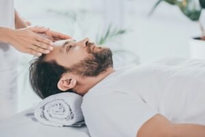 calm bearded man receiving reiki treatment and looking up