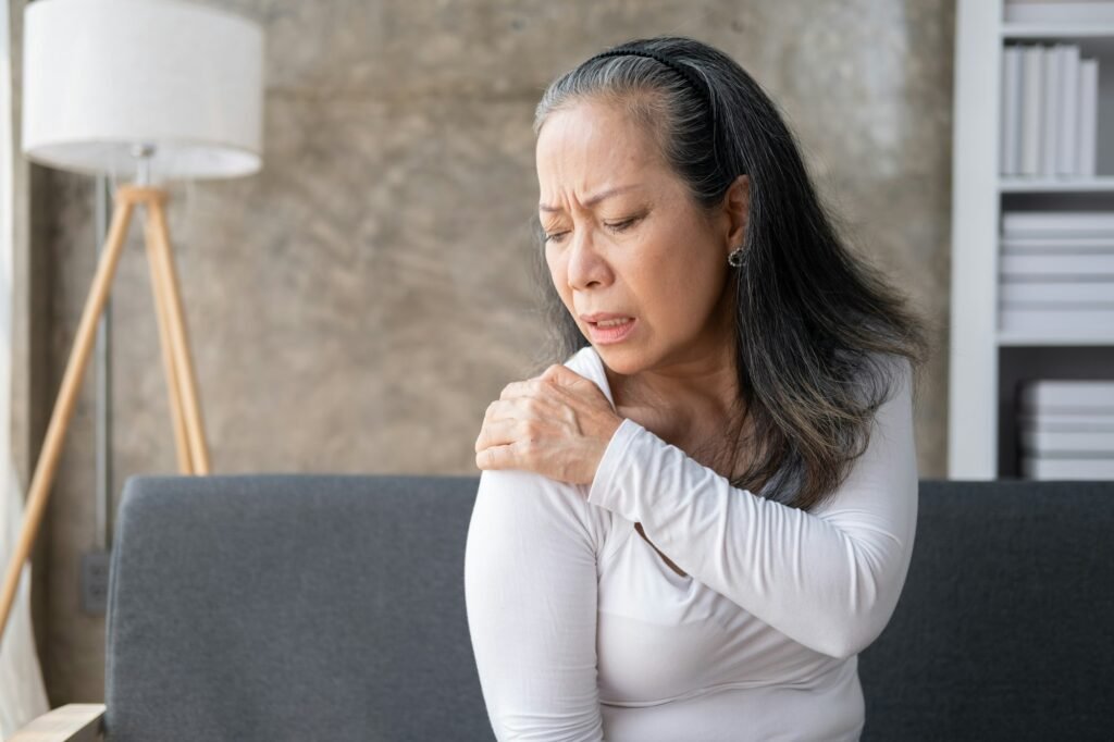 Middle aged asian woman suffers from shoulder joint pain or osteoporosis.