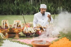 Balinese monk on traditional spiritual ceremony with a lot of sacred accessories and fire smoke
