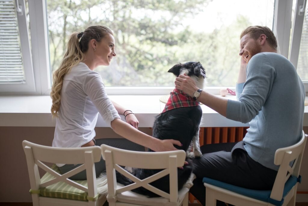 Beautiful couple enjoying companion of their dog at home