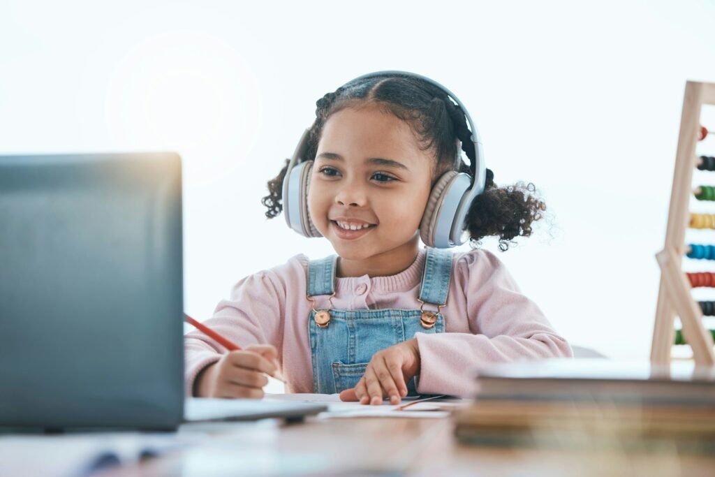 Online education, laptop and headphones of child in e learning, language translation and writing in