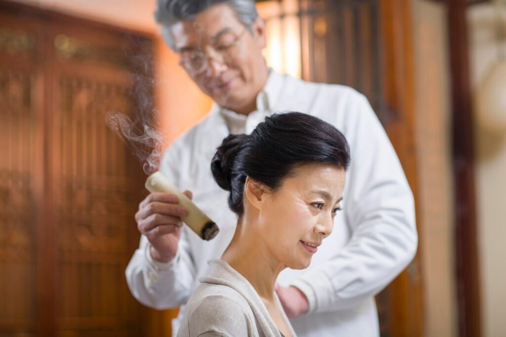 Senior Chinese doctor giving moxibustion