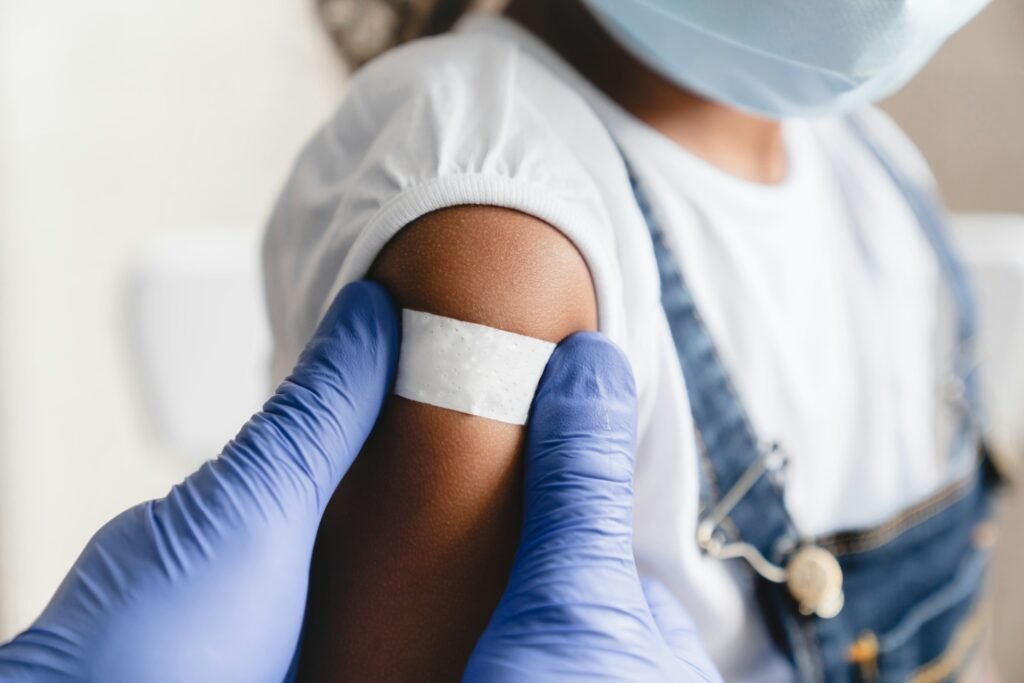 Covid 19 measles, ebola vaccinated. Doctor pediatrician injecting making vaccine to african girl