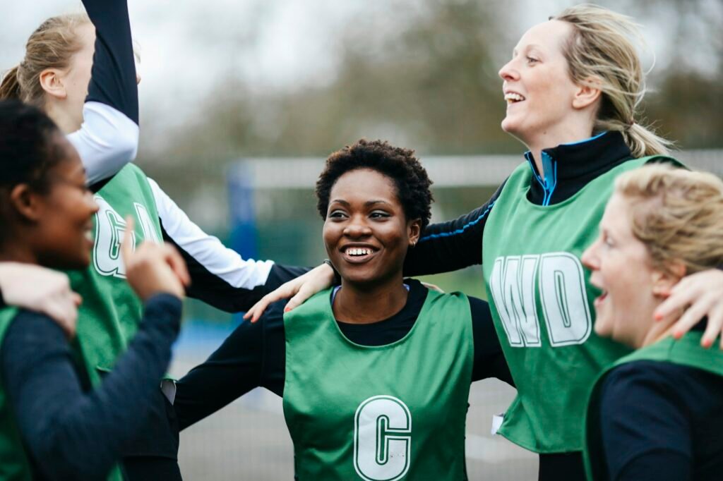 Female netball team celebrating win on netball court
