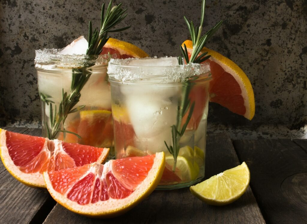 Gin tonic cocktails set. Trendy drinks with lime, lemon, grapefruit, soda and spicy herbs in wine gl