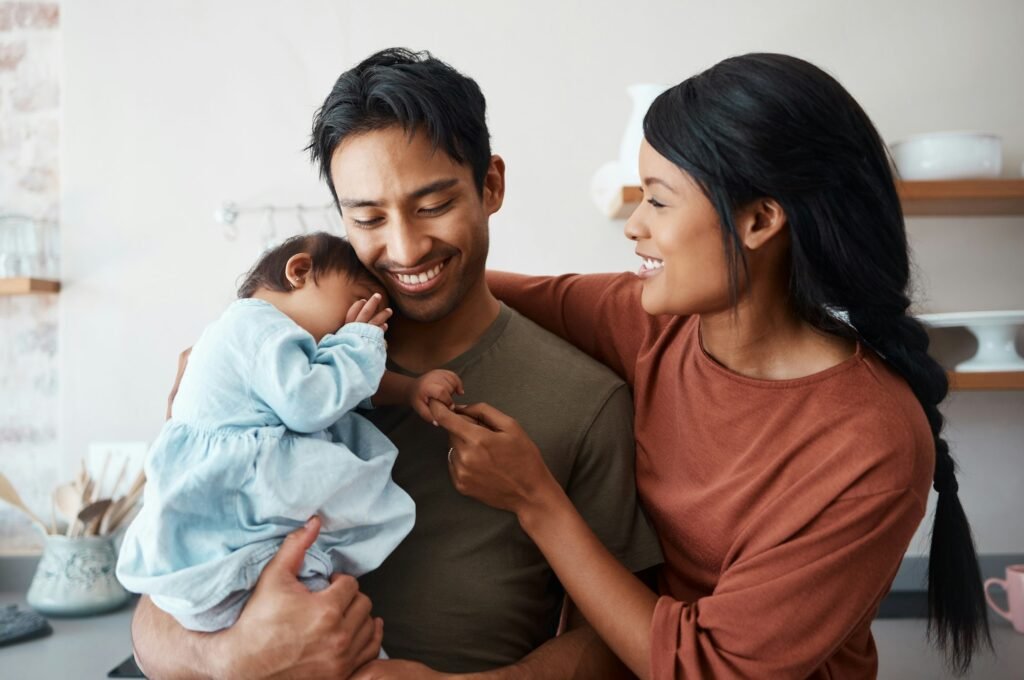 Love, baby and happy parents bonding and caring for their infant child in their comfy home. Happine