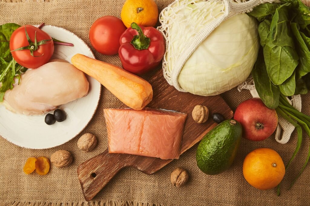 Low carb, FODMAP diet food background with vegetables, fruits, smoked salmon, chicken fillet,