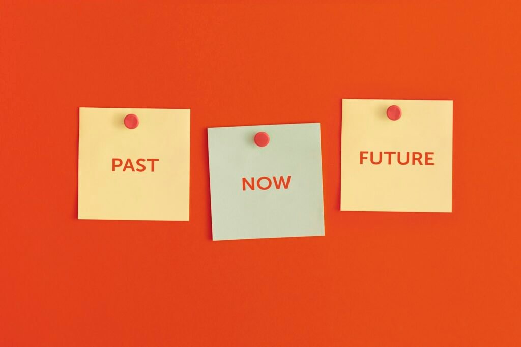 Mock up sticky notes on red background. Past, now, future, time concept.