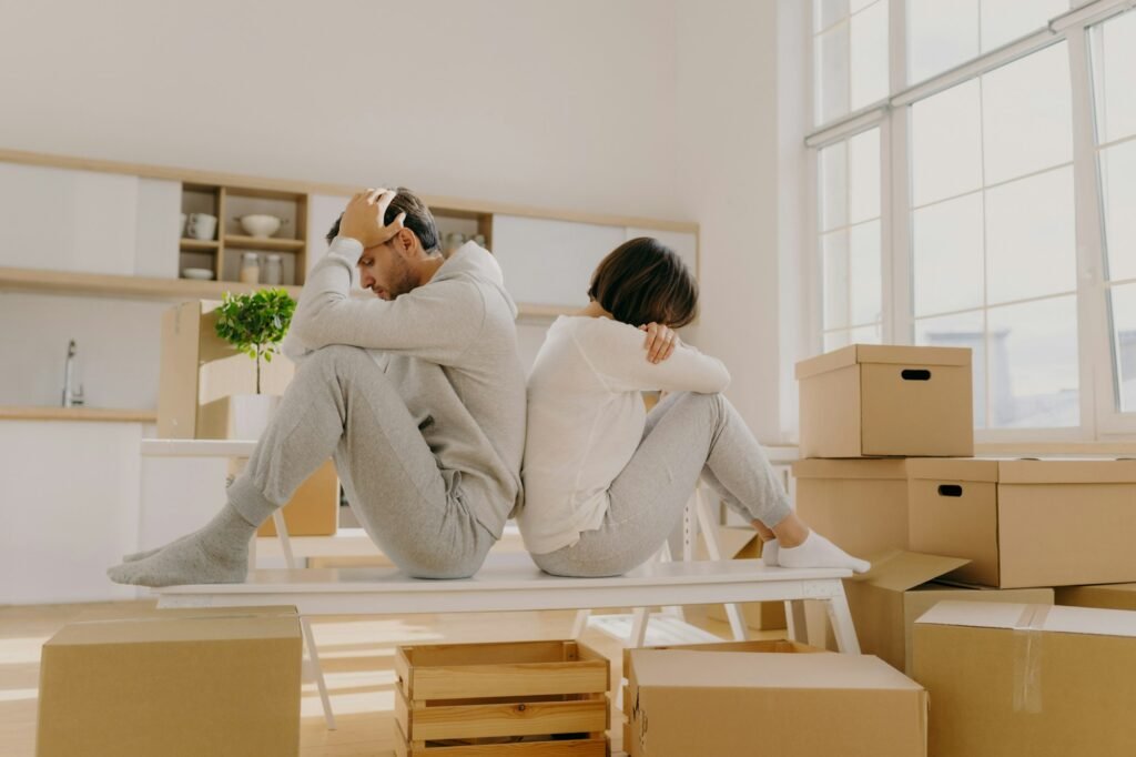Photo of stressful couple get divorse, leave house, start living seperately, sit backs to each other
