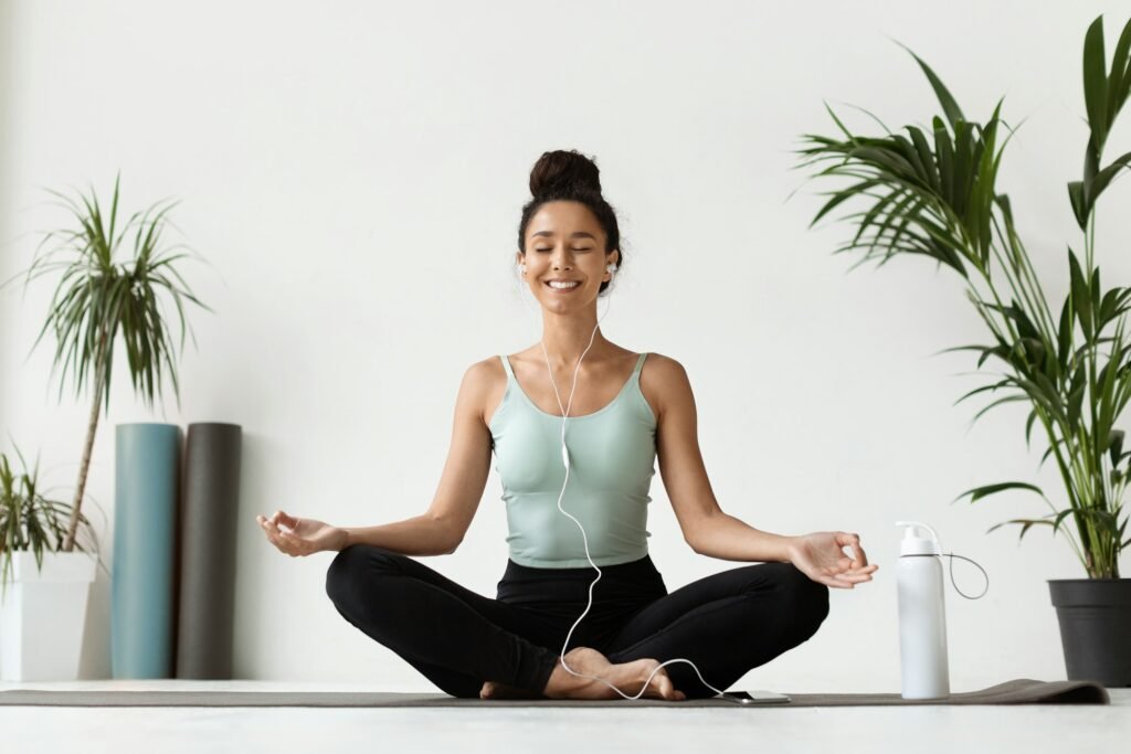 Playlist For Meditation. Smiling Young Woman Listening Music While Meditating In Studio