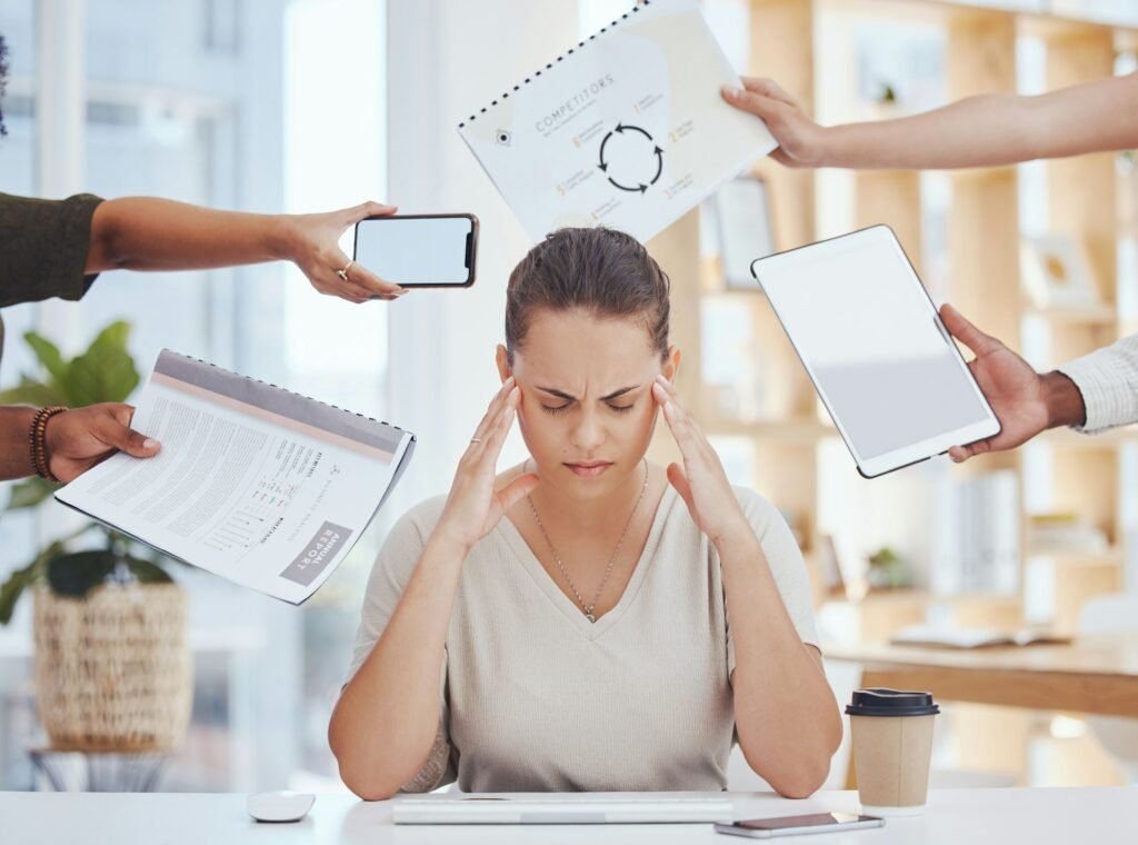Stress, headache, and time management of business woman with project document, tablet and a phone c