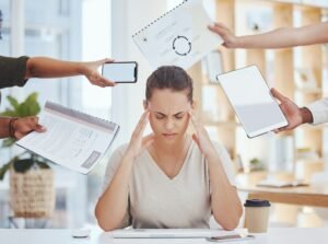 Stress, headache, and time management of business woman with project document, tablet and a phone c