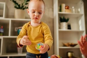 Toddler child playing with modeling clay in a kindergarten or ho